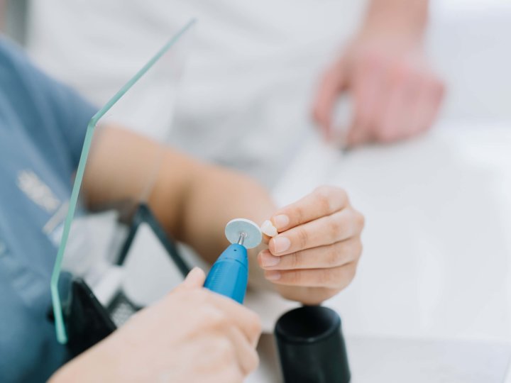 Zahn wird im Dentallabor geschliffen
