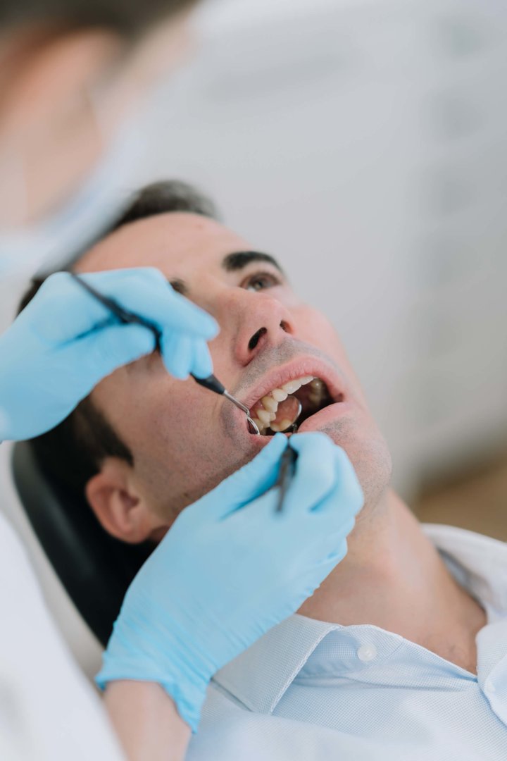 Patient wird mit Instrumenten am Zahn behandelt