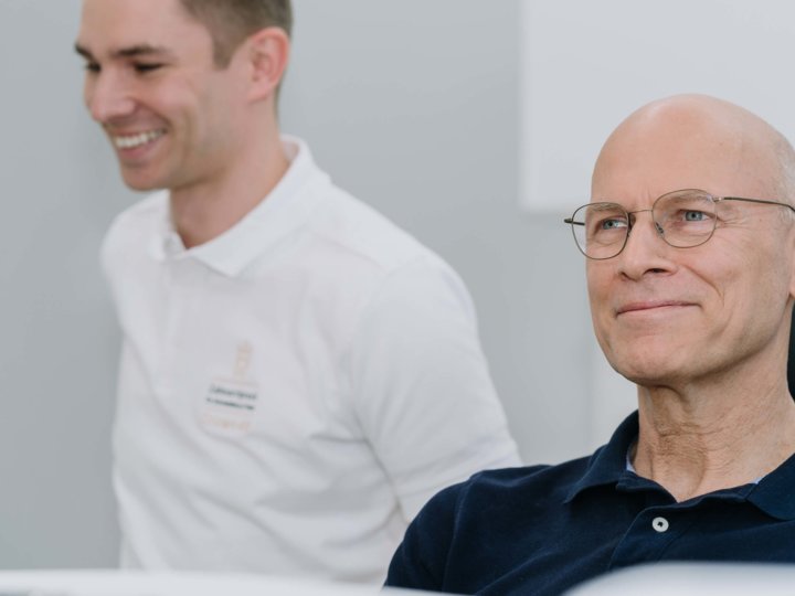 Zufriedener Patient im Behandlungszimmer mit Zahnarzt