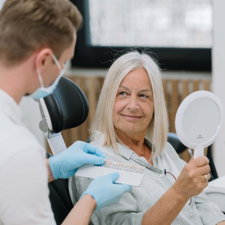 Zahnarzt berät Patientin im Behandlungszimmer