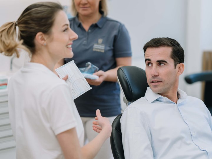 Zahnärztin bereitet sich und den Patienten auf die Behandlung vor
