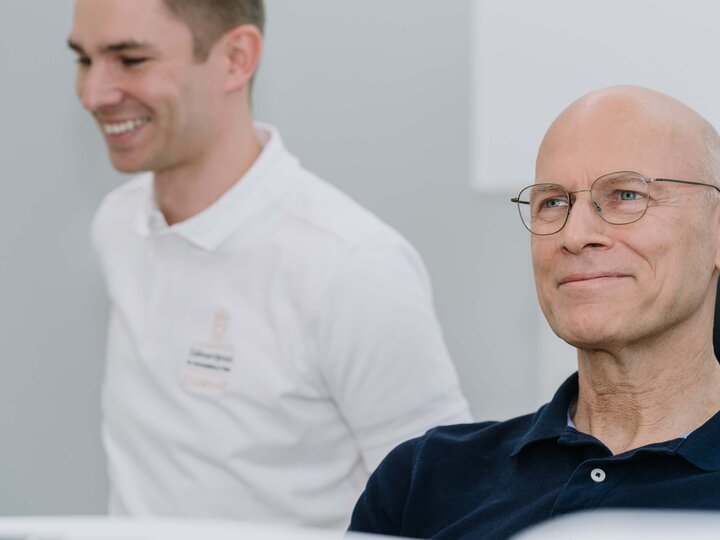 Zufriedener Patient im Behandlungszimmer mit Zahnarzt
