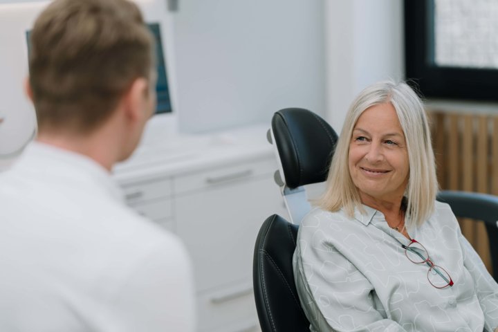 Zahnarzt berät Patientin im Behandlungszimmer
